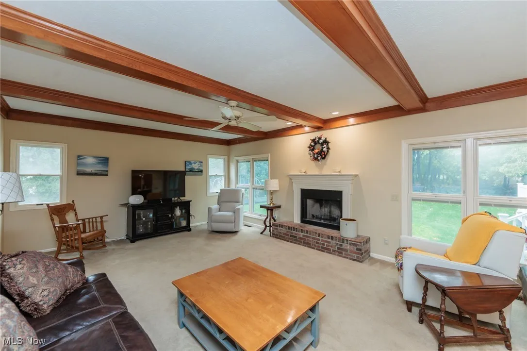 Family room with wood burning fireplace and a wood-beamed ceiling.