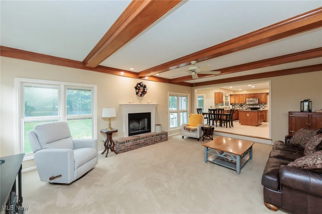 Family room with wood burning fireplace and a wood-beamed ceiling.