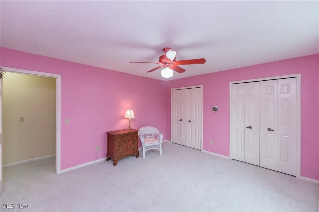 Third of Five Bedrooms with neutral carpeting and a ceiling fan.