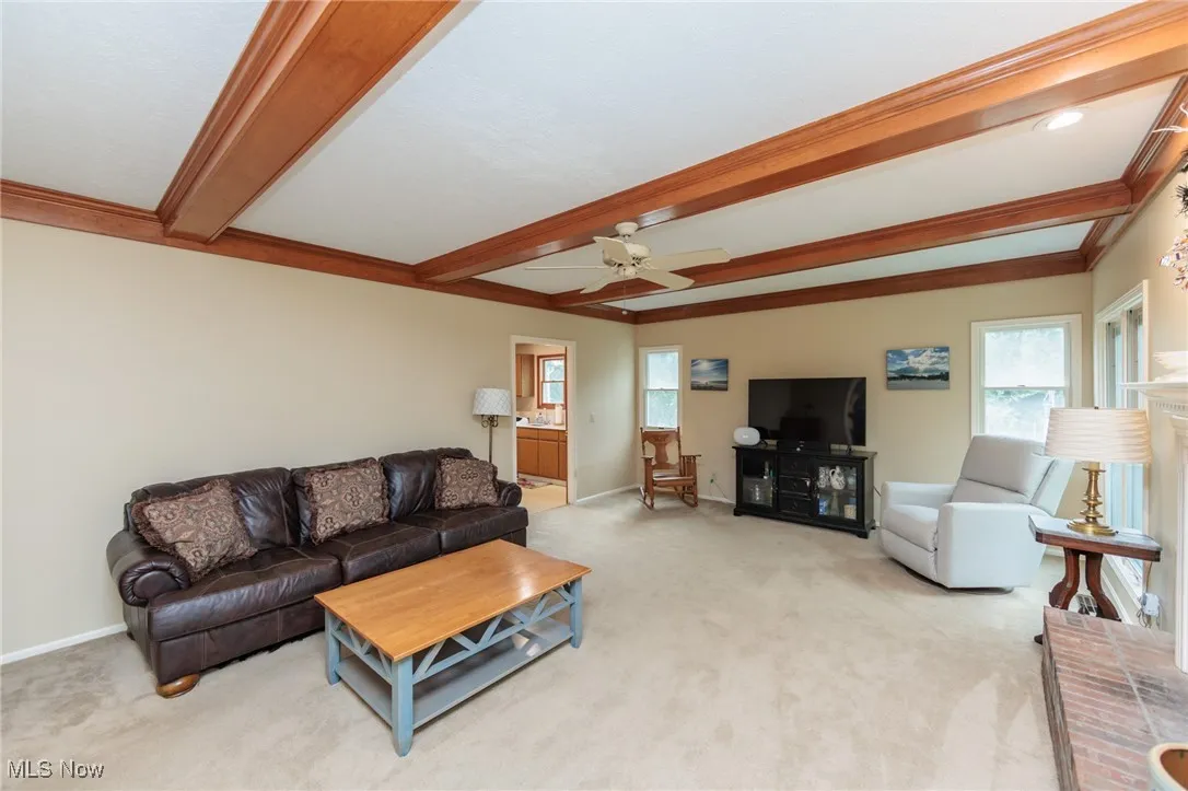 Family room with wood burning fireplace and a wood-beamed ceiling.