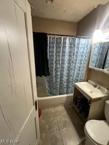 Full bath with vanity, light tile patterned floors, and shower / bathtub combination with curtain
