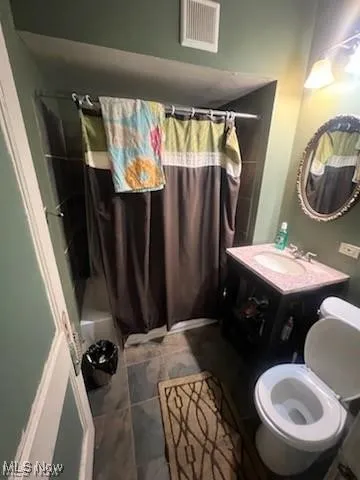 Bathroom with vanity, shower / bath combo, and tile patterned floors