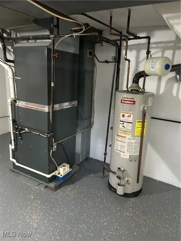 Utility room featuring water heater and heating unit