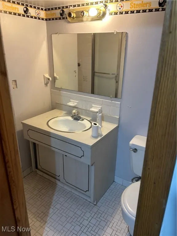 Bathroom featuring vanity, light tile patterned floors, and decorative backsplash