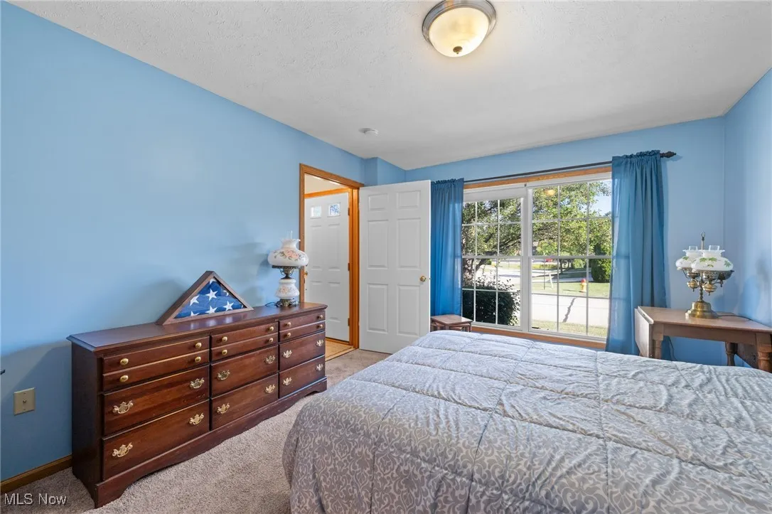 Bedroom with light colored carpet and a textured ceiling