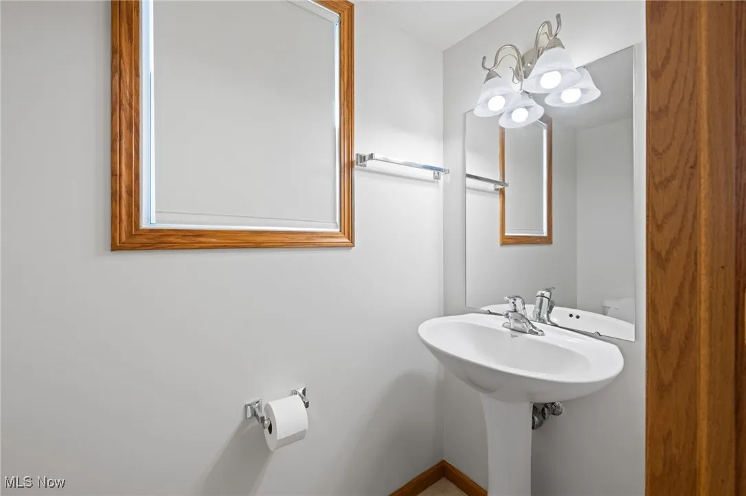 Bathroom featuring a chandelier and baseboards