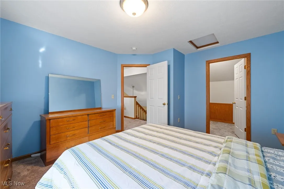 Bedroom with light carpet and attic access