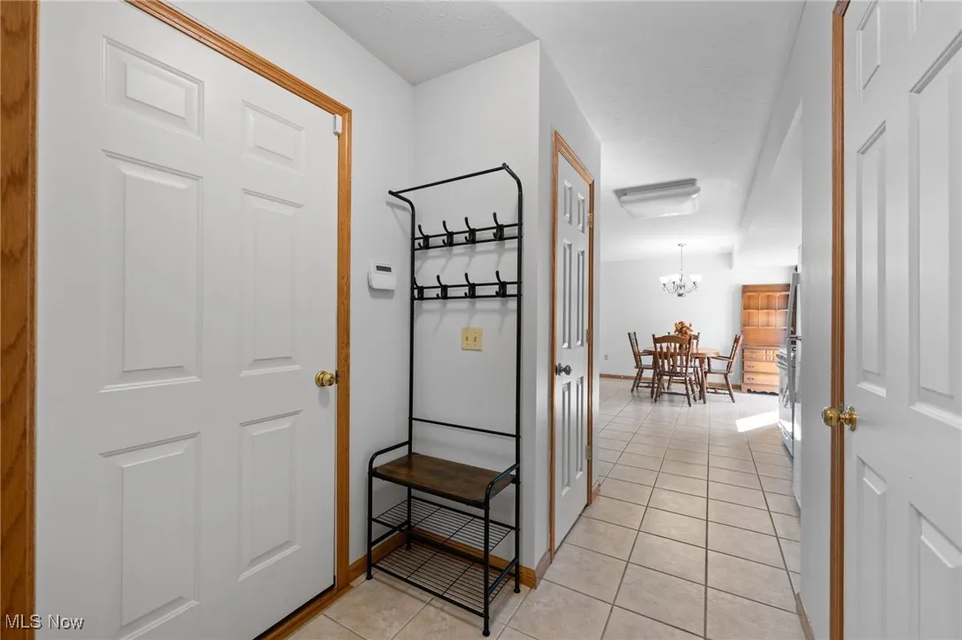 Corridor featuring a chandelier and light tile patterned flooring