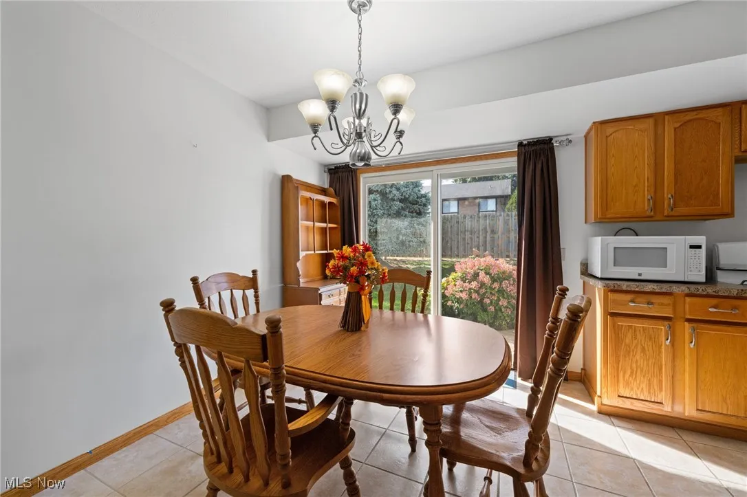 Dining space with light tile patterned floors and a chandelier