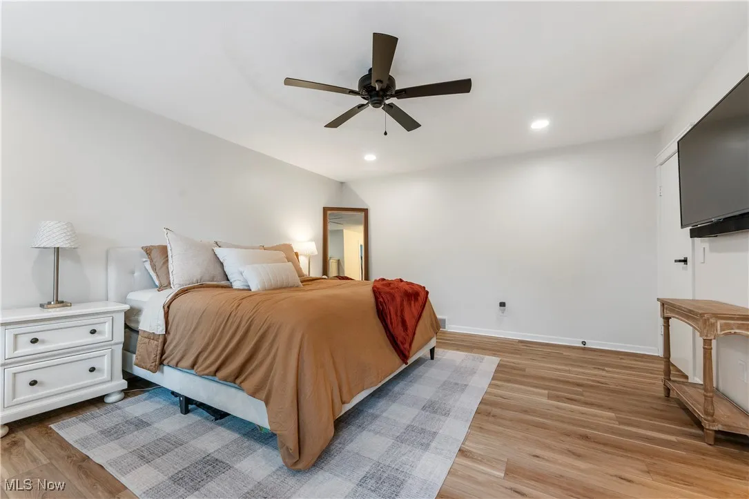 Bedroom with light wood-style floors, recessed lighting, and ceiling fan