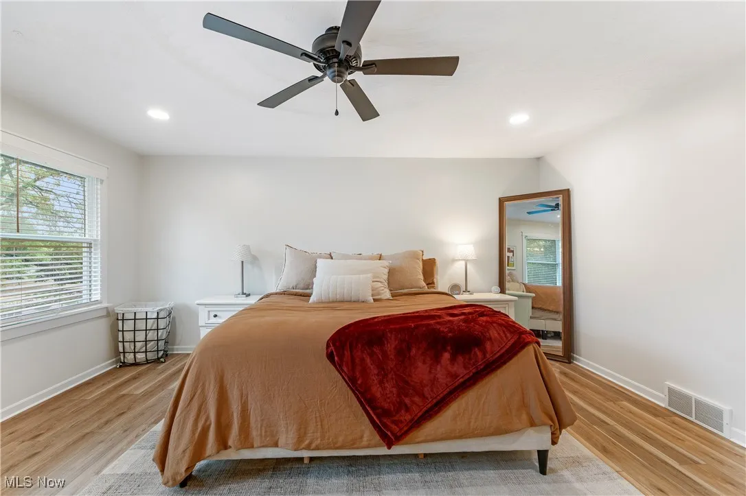 Bedroom featuring light wood finished floors, recessed lighting, multiple windows, and ceiling fan