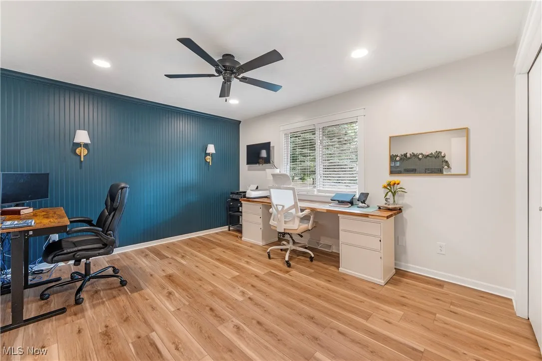 Office with light wood-style floors, ceiling fan, and recessed lighting