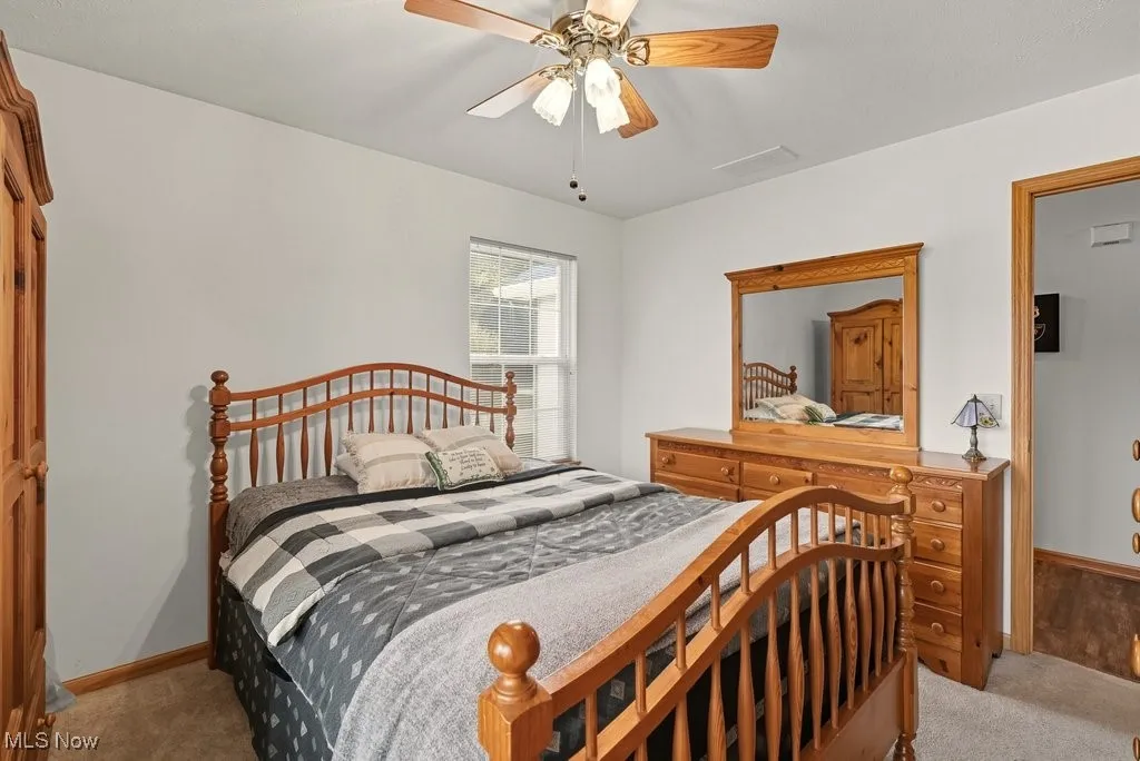 Carpeted bedroom featuring baseboards and a ceiling fan