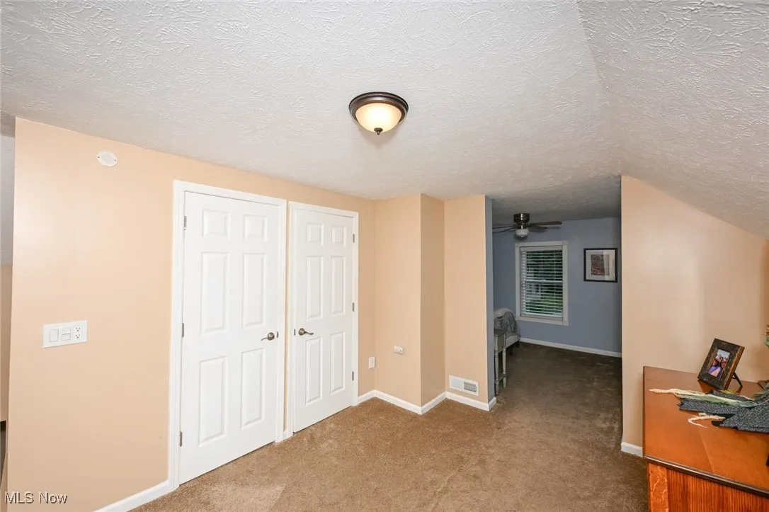 Unfurnished bedroom featuring a textured ceiling and carpet flooring