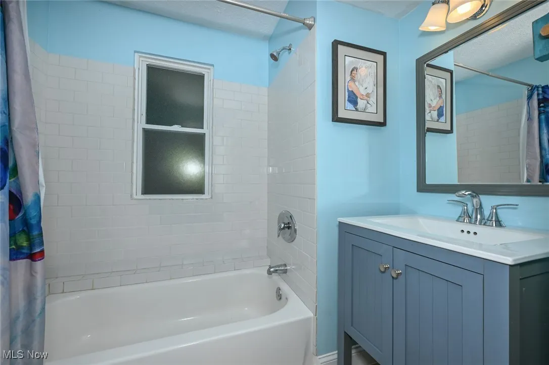 Full bathroom with shower / bath combo,
 vanity