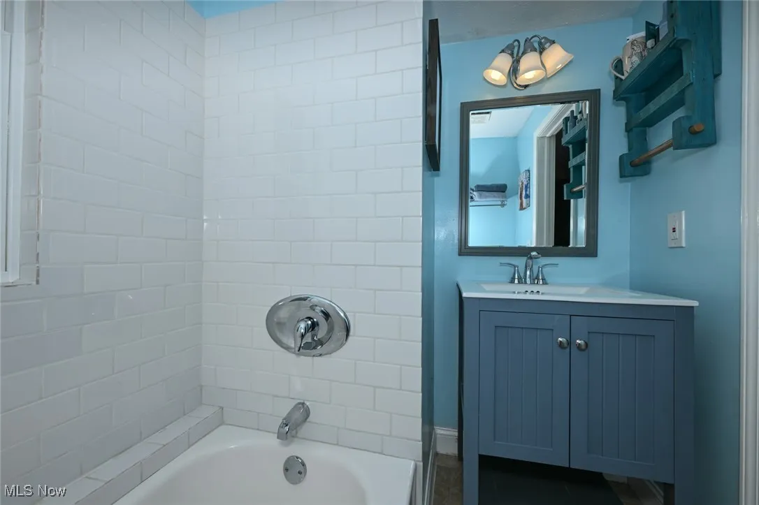 Bathroom with shower / bathtub combination and vanity