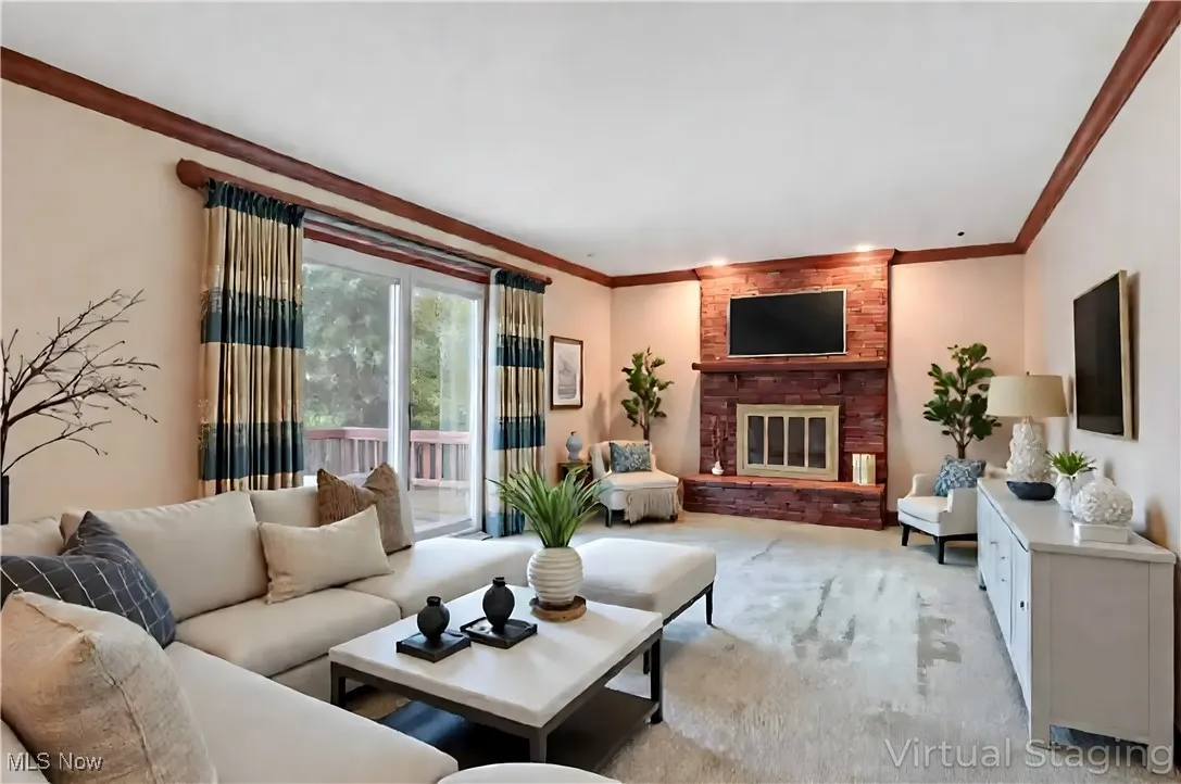 Carpeted living area featuring a fireplace and crown molding