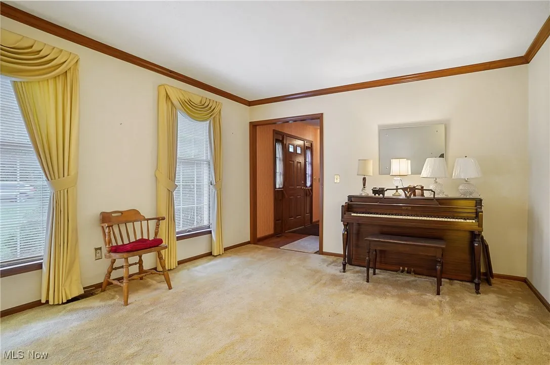 Sitting room featuring ornamental molding and light carpet