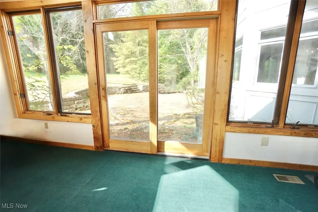 Sliding door from sun room to rear stone patio.