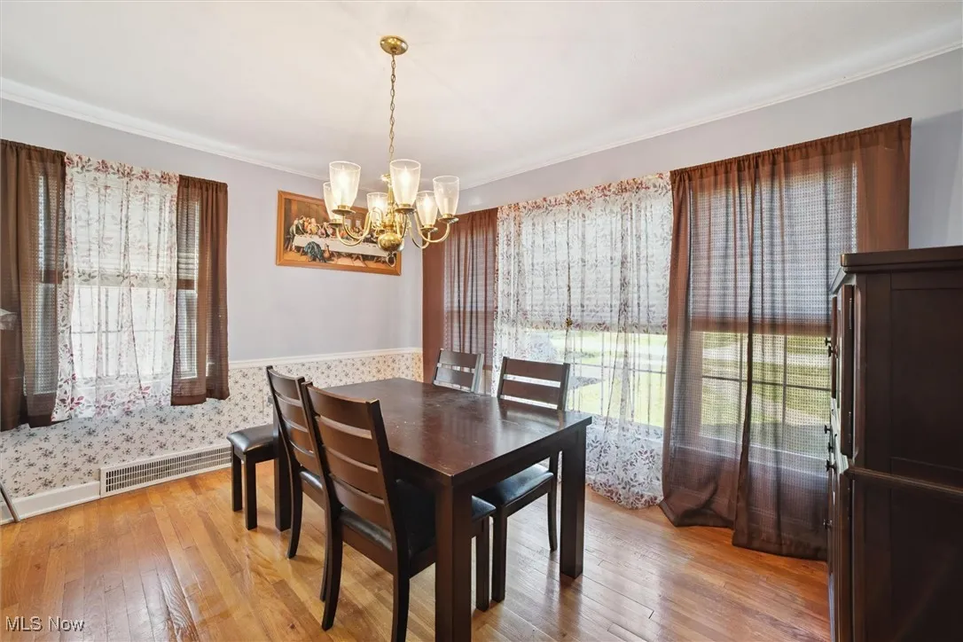 Dining area featuring light wood-type flooring and a chandelier