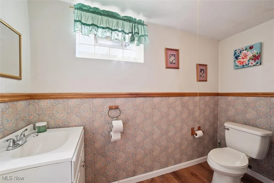 Half bath with vanity and wood finished floors