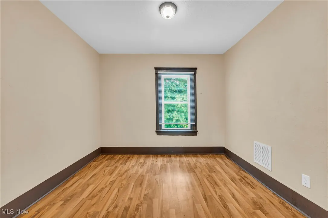 Unfurnished room with light wood-type flooring and baseboards