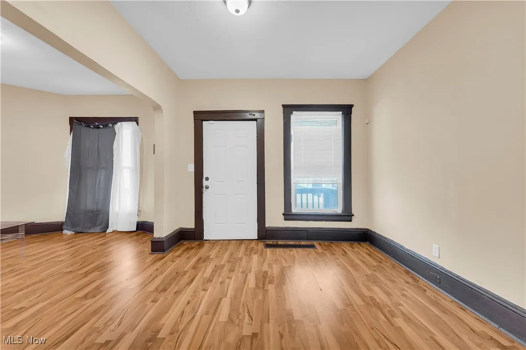 Entryway with light wood finished floors and arched walkways