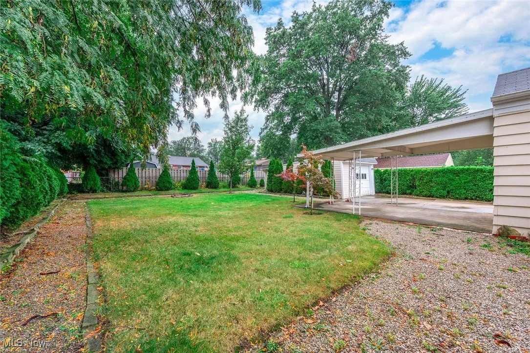 Fenced backyard with an attached carport