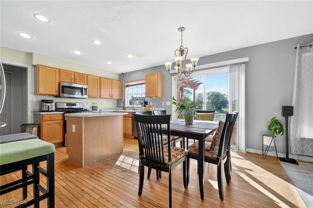 Dining area with light wood-style floors, recessed lighting, and a chandelier