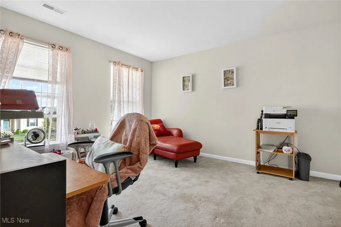 Office space/bedroom featuring light carpet and baseboards