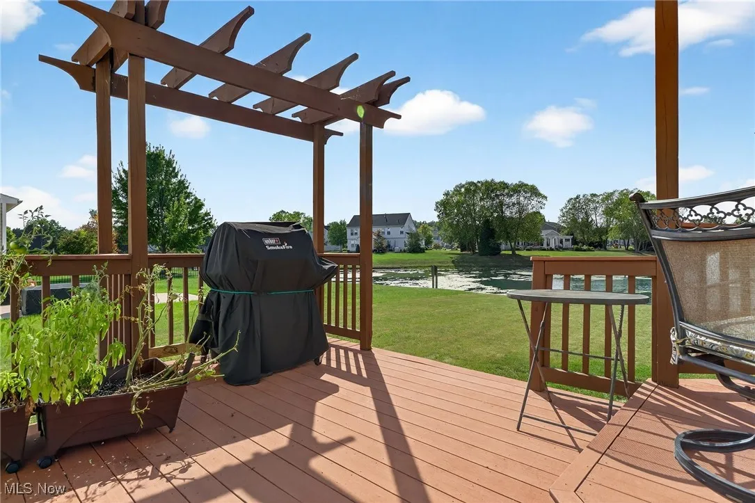 Wooden deck featuring area for grilling, a yard, and a residential view