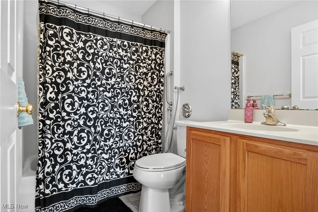 Bathroom featuring vanity, a shower with curtain, and tile patterned flooring