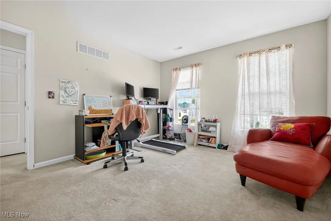 Carpeted office/bedroom featuring baseboards