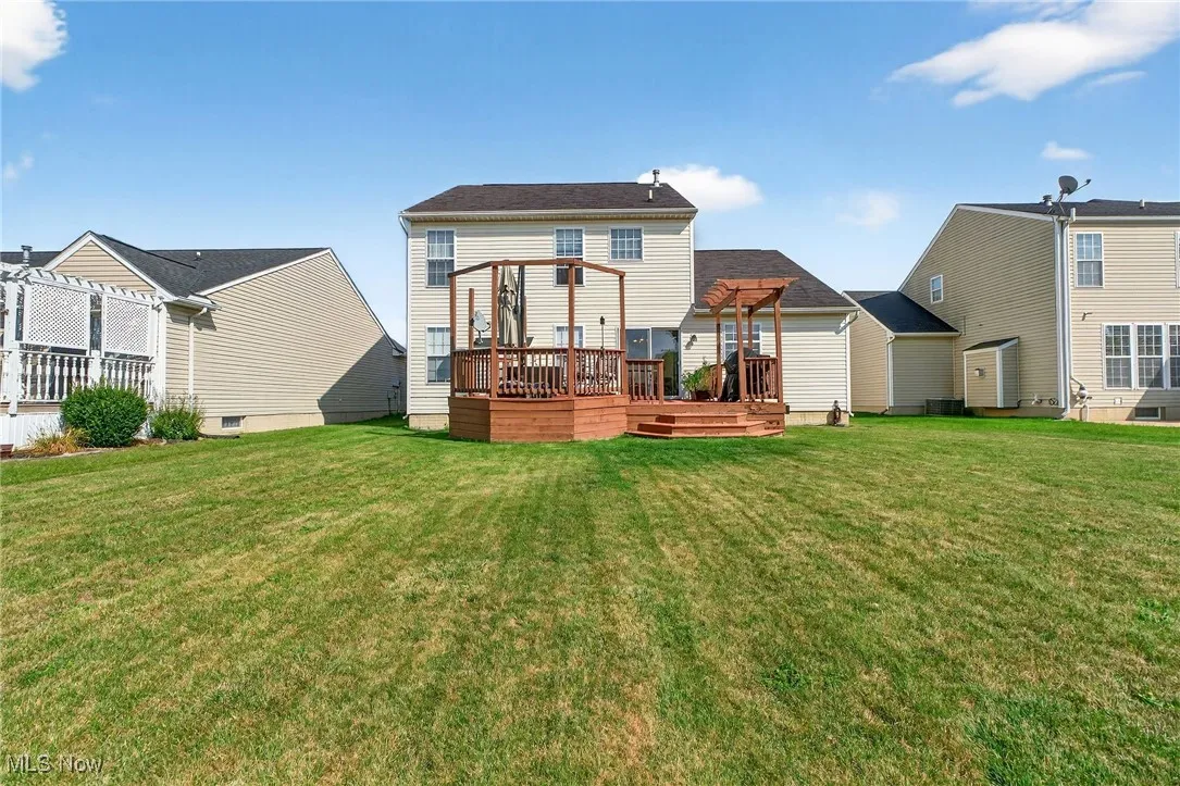 Rear view of property with a wooden deck and a yard