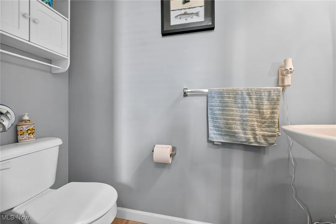 Half bathroom featuring toilet and baseboards