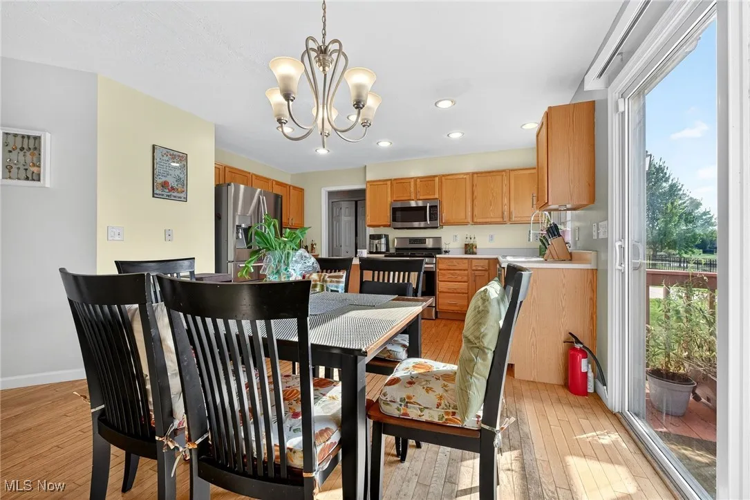 Dining area with light wood-type flooring, a chandelier, and recessed lighting