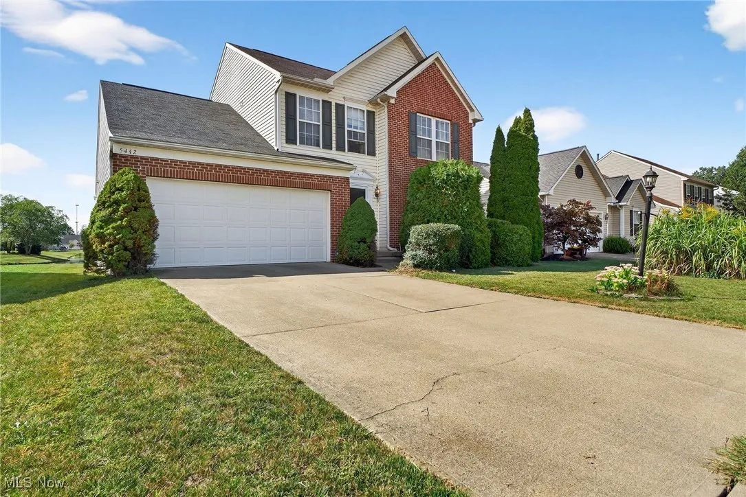 Traditional-style home with brick siding, concrete driveway, and a front yard