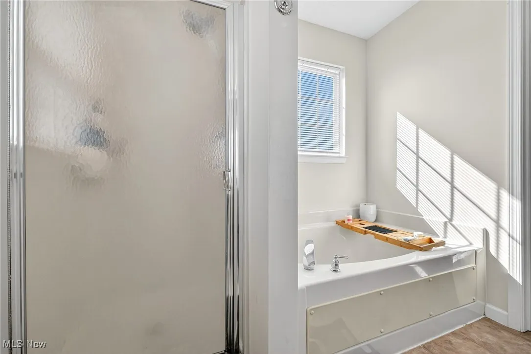 Bathroom with plenty of natural light, a shower stall, and a bath