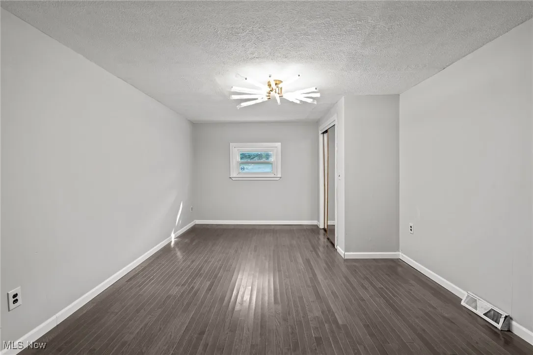 Spare room with dark wood finished floors and a textured ceiling