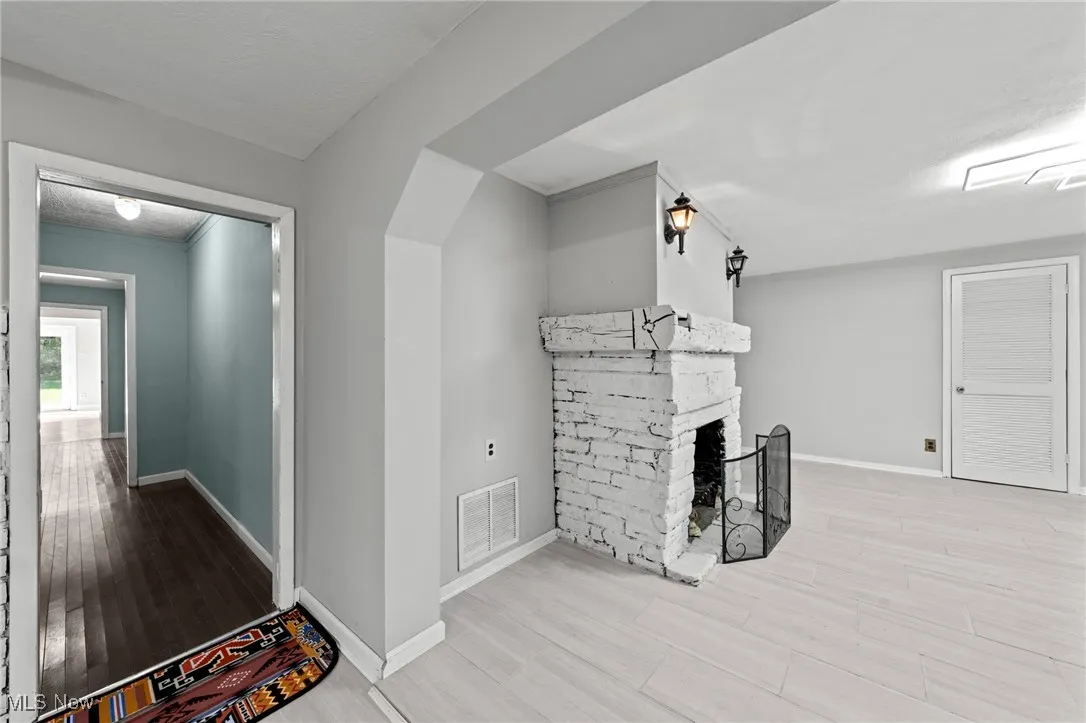 Unfurnished living room featuring wood finished floors, a fireplace, and a textured ceiling