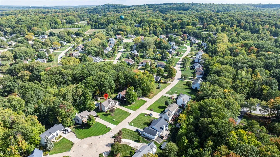 Aerial view of property and surrounding area with nearby suburban area