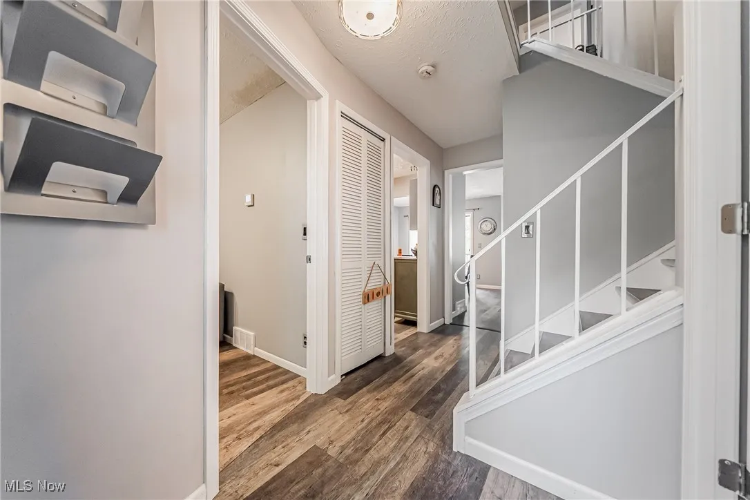 Entryway featuring a textured ceiling, wood finished floors, and stairs