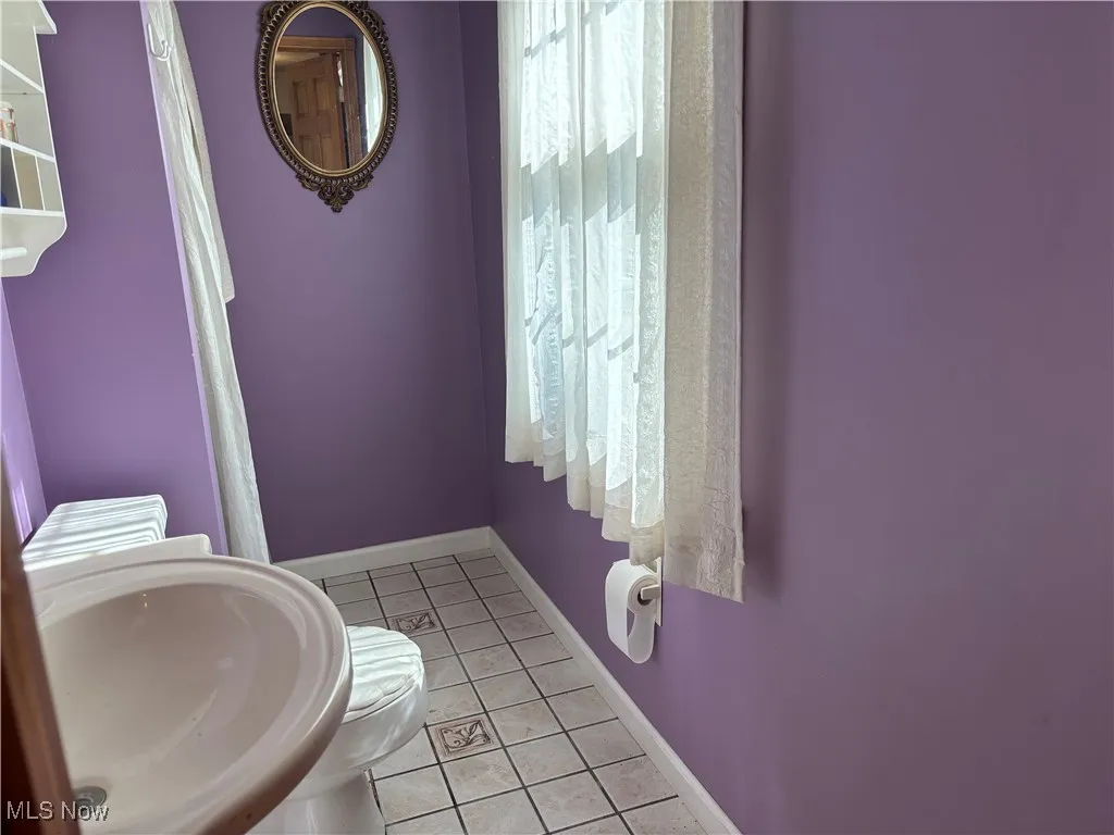 Bathroom featuring light tile patterned floors and baseboards