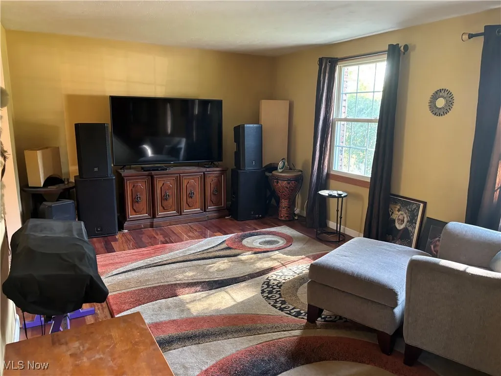 Living room featuring dark wood-type flooring and baseboards