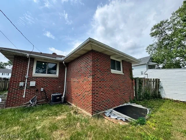 View of home's exterior with brick siding and a cooling unit