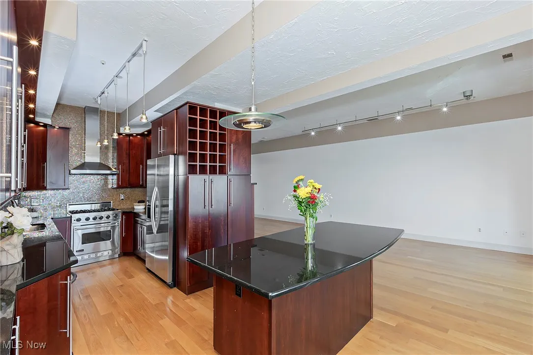 The kitchen is ready and fully equipped with stainless steel appliances, warm wood cabinetry and stone countertops.