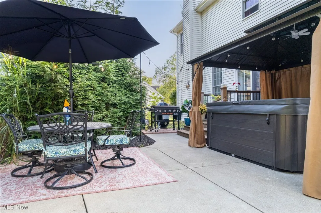 View of patio with a hot tub, outdoor dining area, and a gazebo