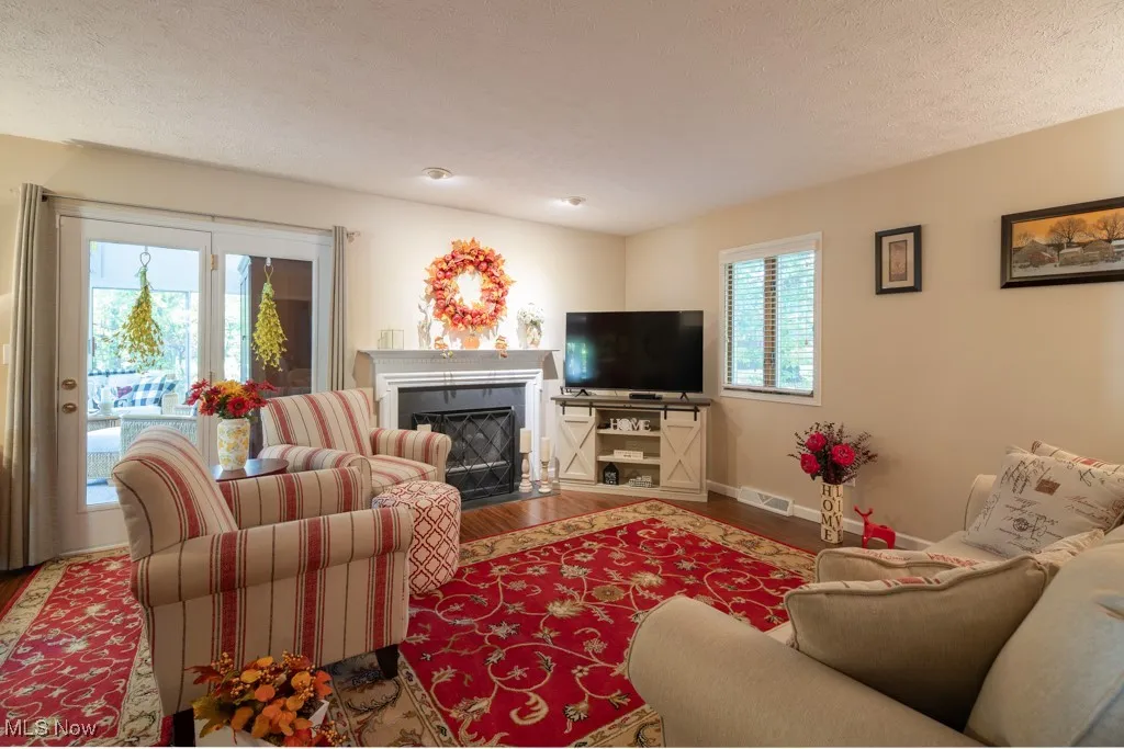 Living area featuring a fireplace with flush hearth, and wood finished floors