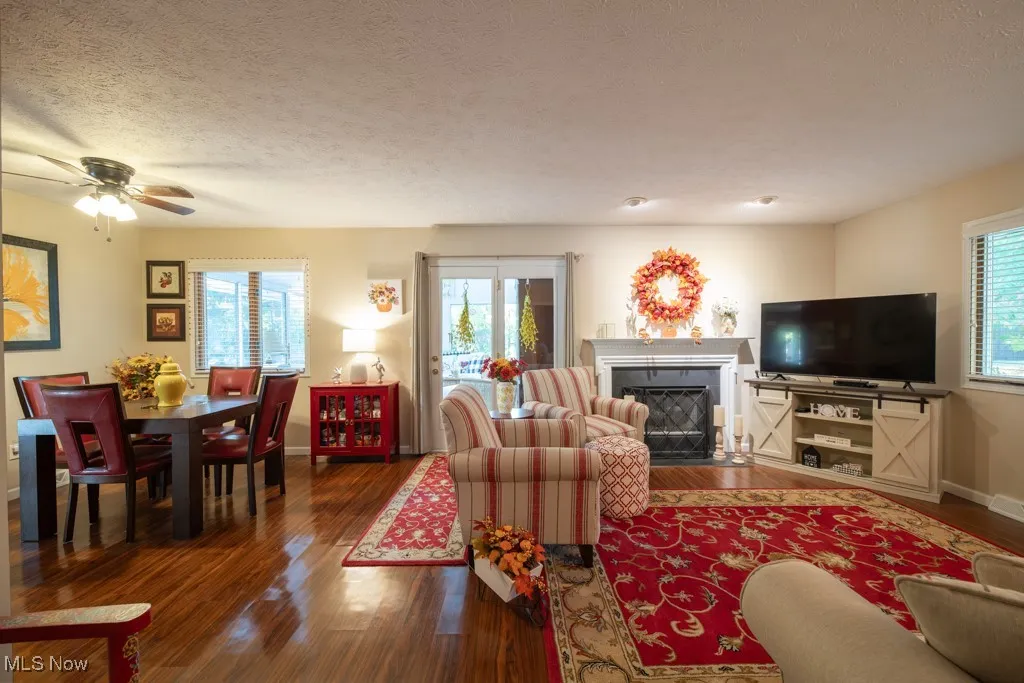 Living room with a fireplace with flush hearth, and wood finished floors