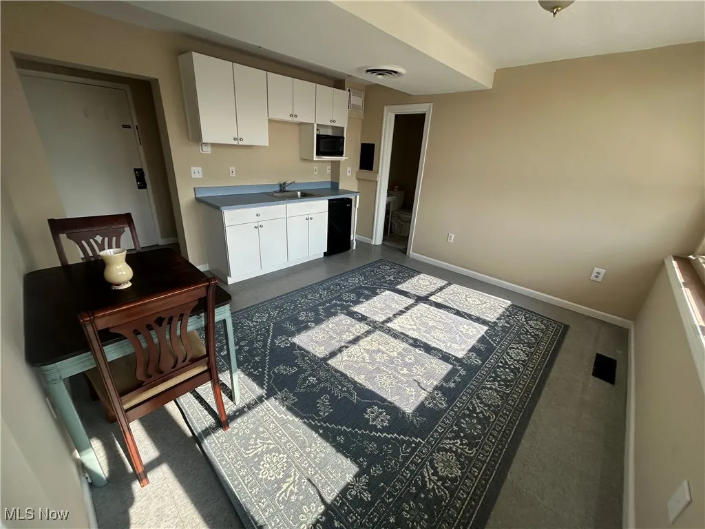 Kitchen featuring white cabinets, refrigerator, and microwave.